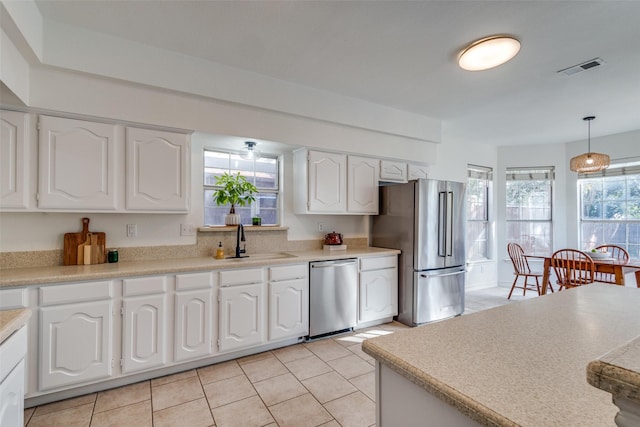 kitchen with sink, pendant lighting, white cabinets, and stainless steel appliances