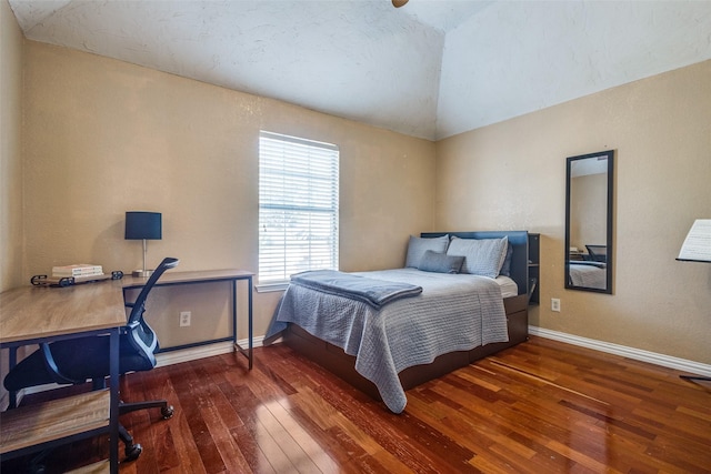 bedroom with vaulted ceiling and dark hardwood / wood-style flooring