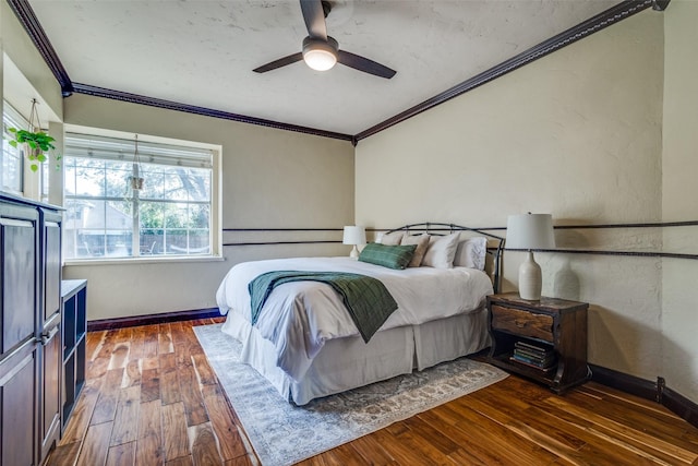 bedroom with ceiling fan, dark wood-type flooring, and crown molding