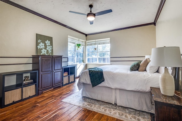 bedroom featuring ceiling fan, dark hardwood / wood-style flooring, and ornamental molding