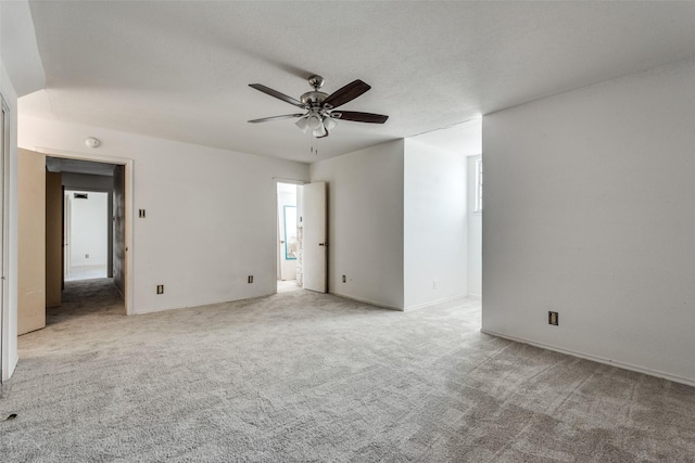 carpeted spare room featuring a textured ceiling and ceiling fan