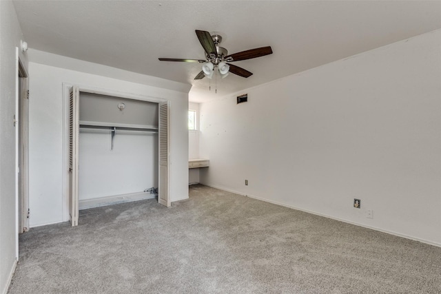 unfurnished bedroom featuring ceiling fan, light carpet, and a closet