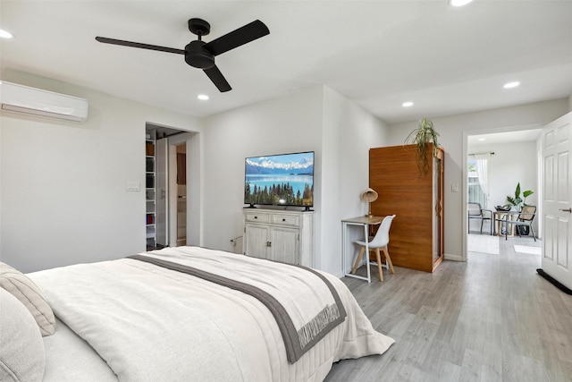 bedroom featuring recessed lighting, light wood-type flooring, a ceiling fan, and a wall mounted AC