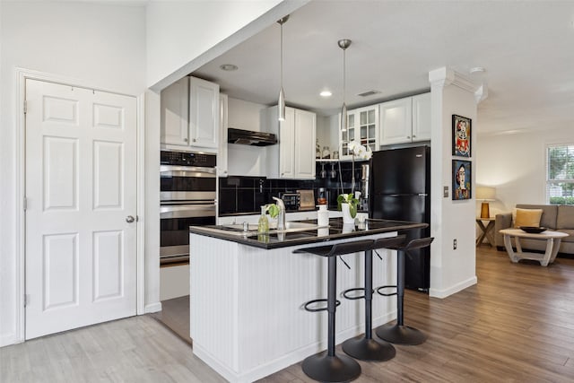 kitchen with glass insert cabinets, freestanding refrigerator, white cabinets, dark countertops, and double oven