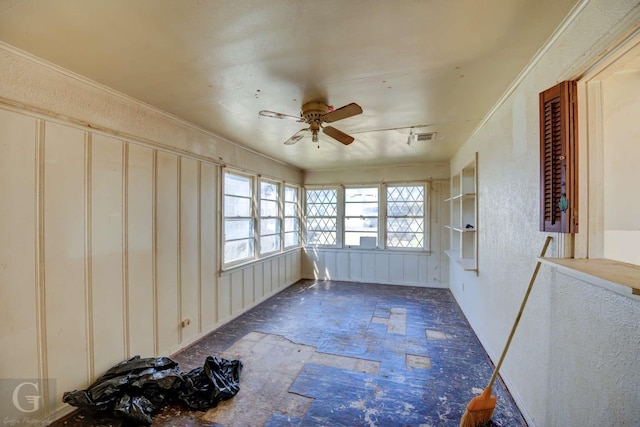 unfurnished sunroom featuring ceiling fan