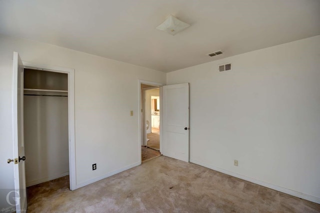 unfurnished bedroom with light carpet and a closet