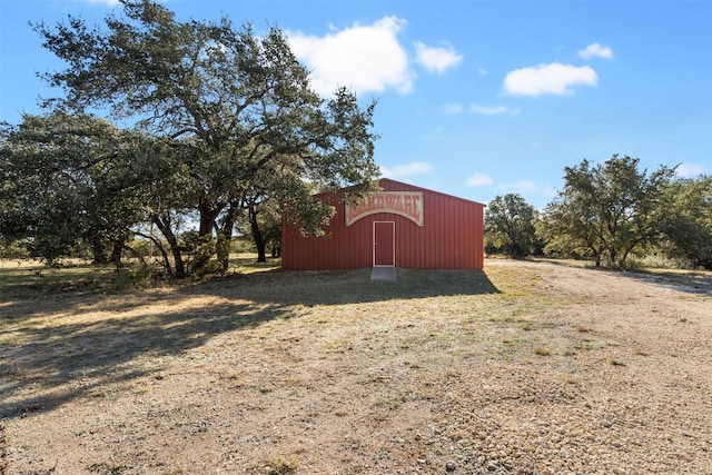 view of outbuilding featuring a rural view and a yard