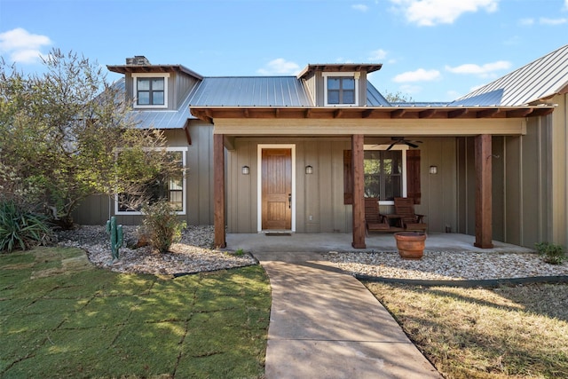 property entrance featuring ceiling fan, a lawn, and a porch