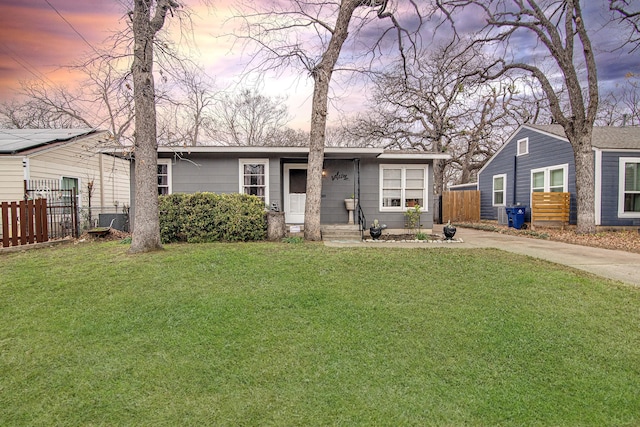 view of front facade with central AC unit and a yard