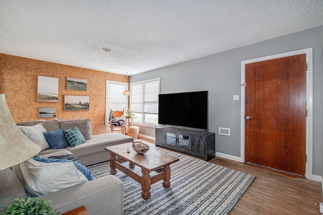 living room with a textured ceiling and hardwood / wood-style floors