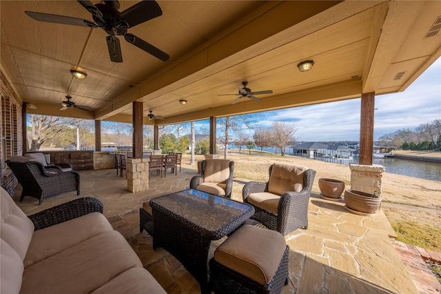 view of patio / terrace with a water view, an outdoor living space, and ceiling fan