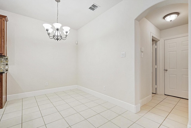 unfurnished dining area featuring an inviting chandelier and light tile patterned flooring