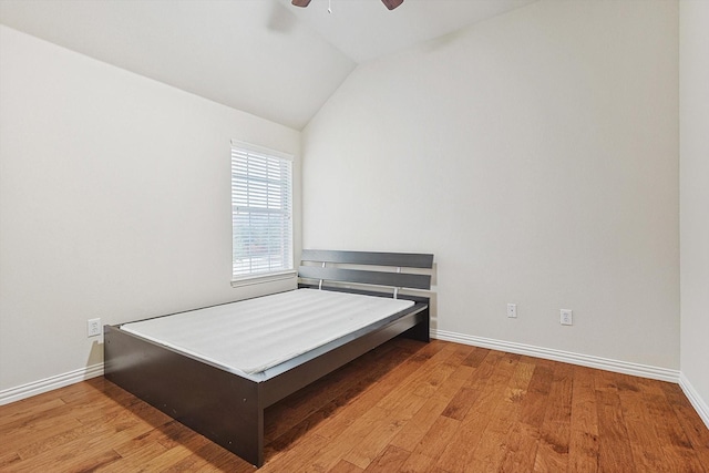 bedroom featuring ceiling fan, lofted ceiling, and light wood-type flooring