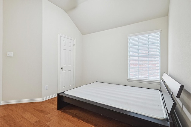 bedroom with lofted ceiling and hardwood / wood-style flooring