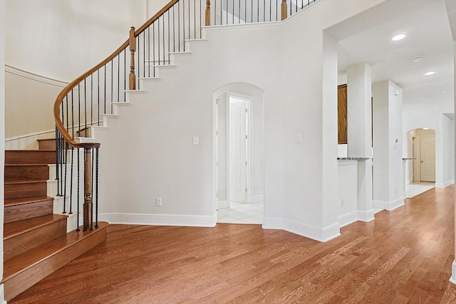 stairs featuring a high ceiling and hardwood / wood-style flooring