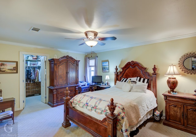 carpeted bedroom with crown molding, ceiling fan, a spacious closet, and a closet