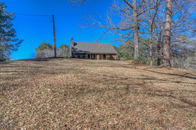 rear view of house featuring a lawn