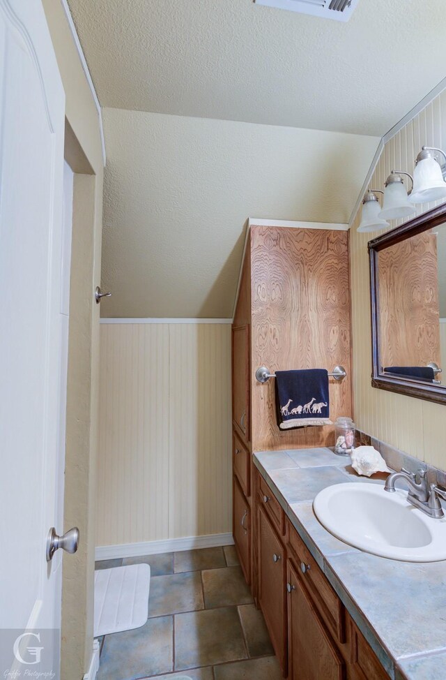 bedroom featuring light carpet, a textured ceiling, vaulted ceiling, and ceiling fan