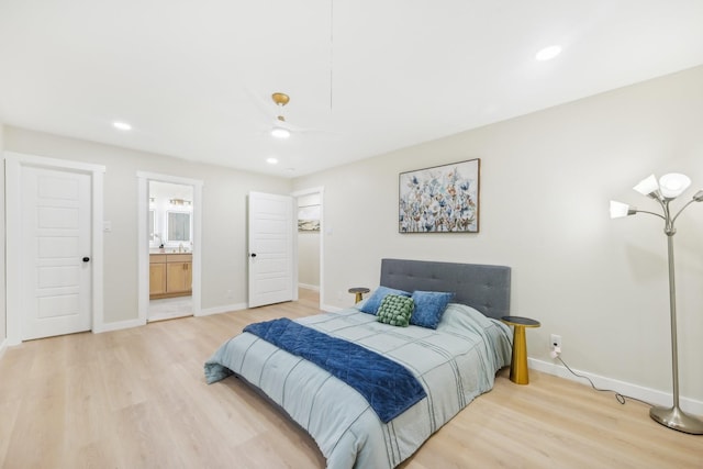 bedroom with ceiling fan, light wood-type flooring, and ensuite bath