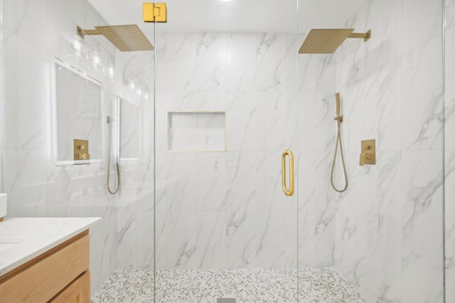 bathroom with vanity and a shower with door