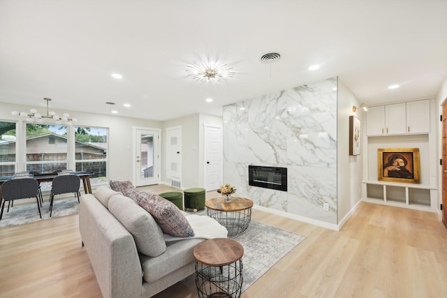 living room featuring heating unit, light wood-type flooring, and a fireplace