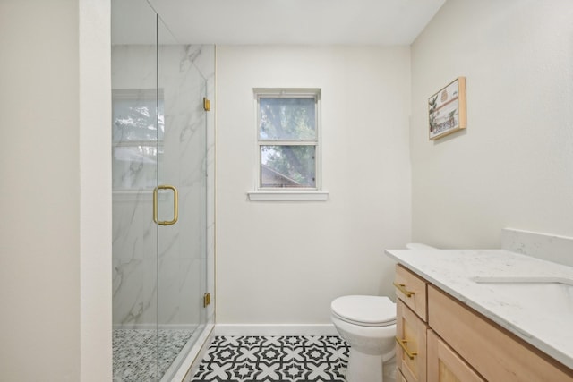 bathroom with vanity, a shower with shower door, and toilet