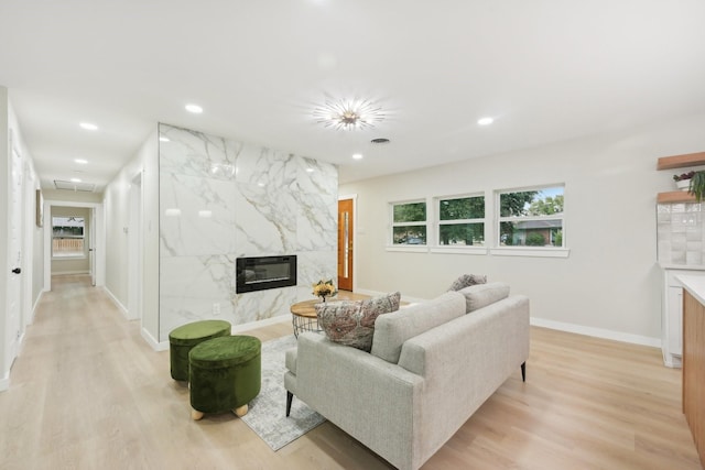 living room with a fireplace and light wood-type flooring