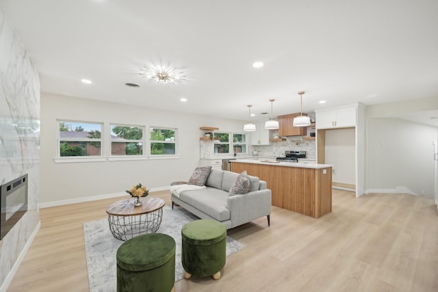 living room featuring light hardwood / wood-style flooring, a high end fireplace, and heating unit