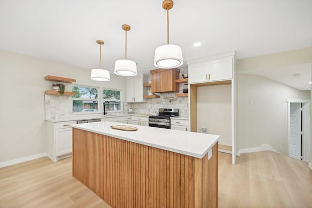 kitchen featuring backsplash, appliances with stainless steel finishes, a kitchen island, and white cabinets