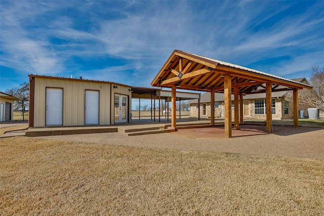 surrounding community featuring an outdoor structure and a patio