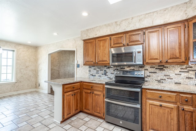 kitchen with light stone counters, kitchen peninsula, decorative backsplash, and stainless steel appliances