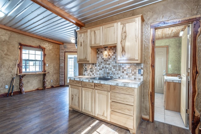 kitchen with backsplash, beam ceiling, wood-type flooring, sink, and light brown cabinetry