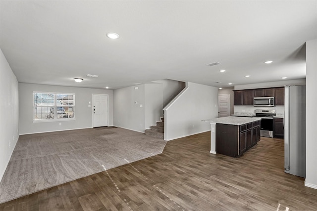 kitchen with stainless steel appliances, hardwood / wood-style flooring, dark brown cabinetry, and a center island