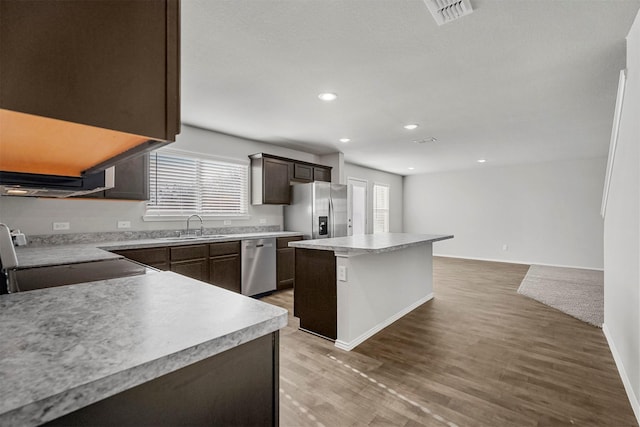 kitchen with a wealth of natural light, appliances with stainless steel finishes, sink, and a center island