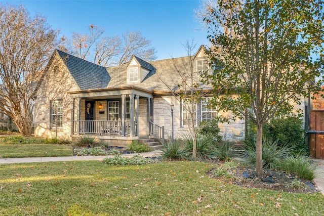 cape cod house with covered porch and a front lawn