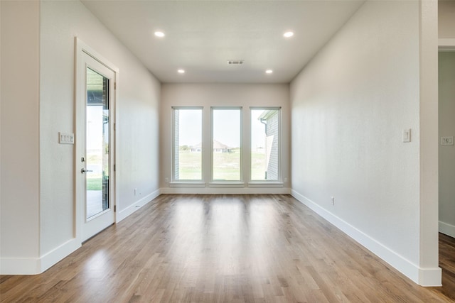 spare room with plenty of natural light and light hardwood / wood-style floors