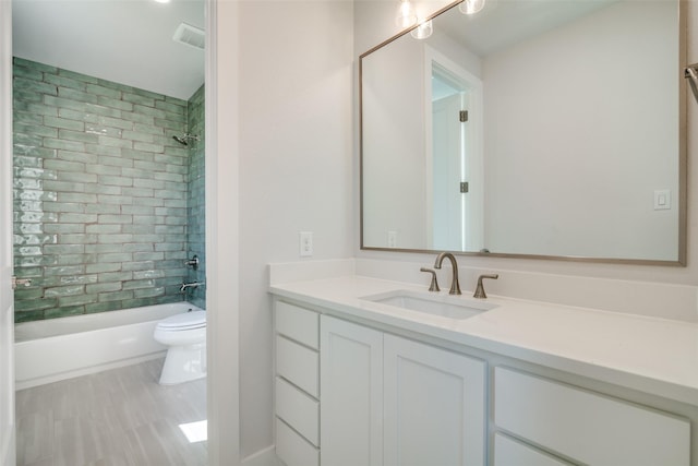 full bathroom with tiled shower / bath combo, vanity, and toilet