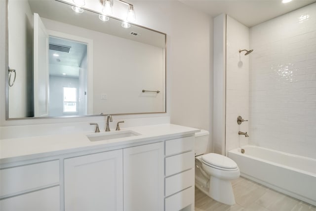 full bathroom featuring tiled shower / bath combo, vanity, and toilet