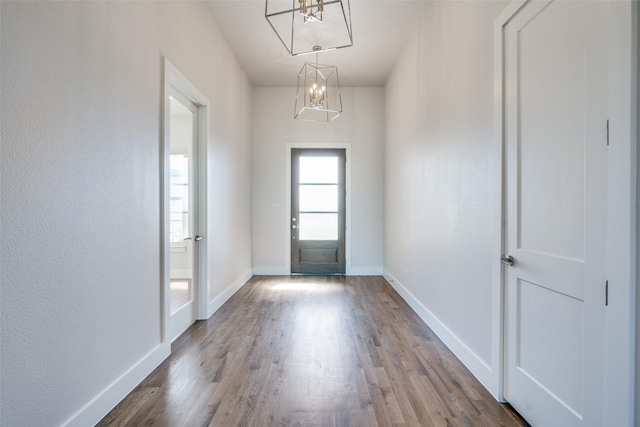 foyer featuring wood-type flooring and an inviting chandelier