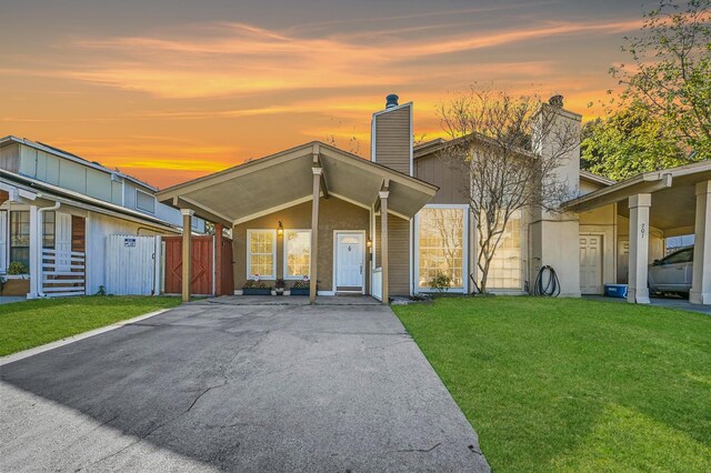 view of front of property featuring a front lawn and a carport