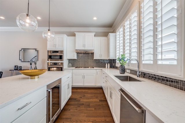 kitchen featuring decorative backsplash, sink, appliances with stainless steel finishes, white cabinets, and beverage cooler