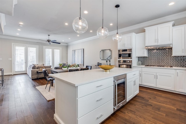 kitchen featuring pendant lighting, white cabinetry, and beverage cooler