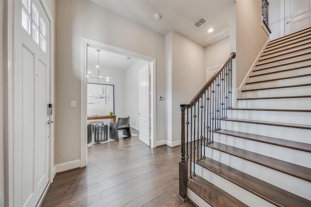 foyer entrance featuring dark hardwood / wood-style flooring and a notable chandelier