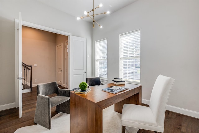 office with dark hardwood / wood-style flooring and an inviting chandelier