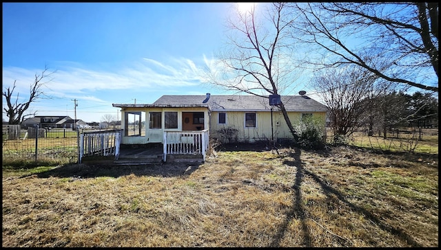 rear view of property with a yard and a wooden deck