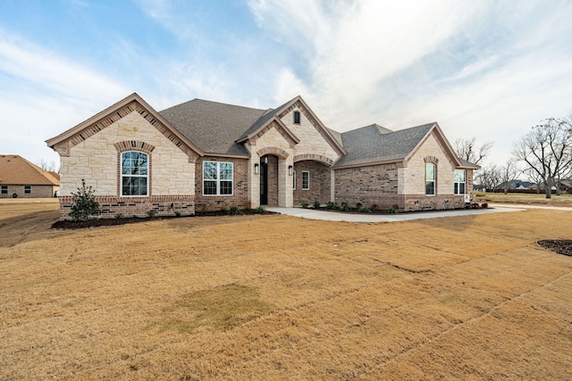 french provincial home with a front lawn