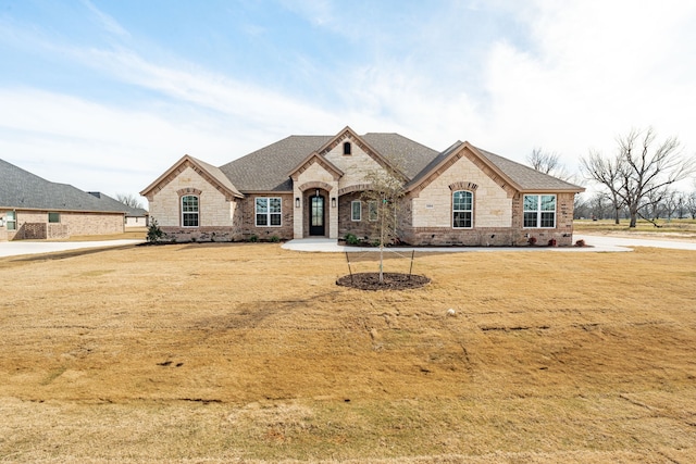 french country home featuring a front lawn