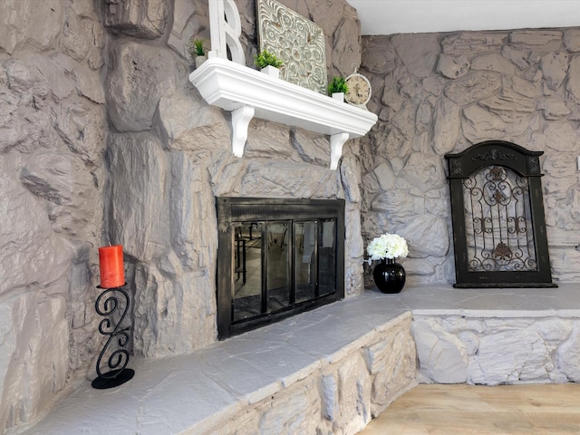 room details featuring hardwood / wood-style flooring and a stone fireplace