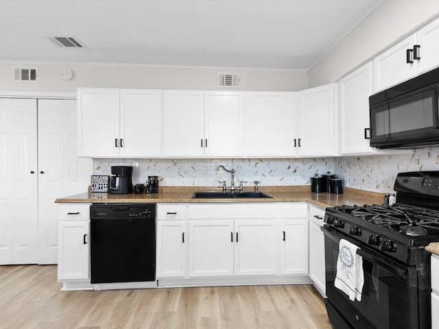 kitchen with white cabinets, black appliances, sink, backsplash, and light wood-type flooring