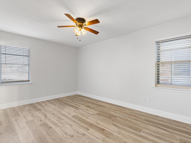 empty room with ceiling fan and light hardwood / wood-style floors